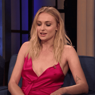 A Woman In A Pink Dress Is Sitting On A Blue Couch GIF