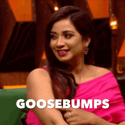 A Woman In A Pink Dress Is Sitting On A Green Couch With The Word Goosebumps On The Bottom GIF