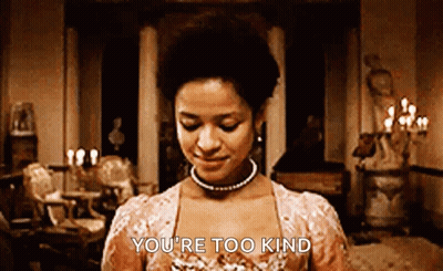 A Woman In A Pink Dress Is Standing In A Room And Smiling . GIF