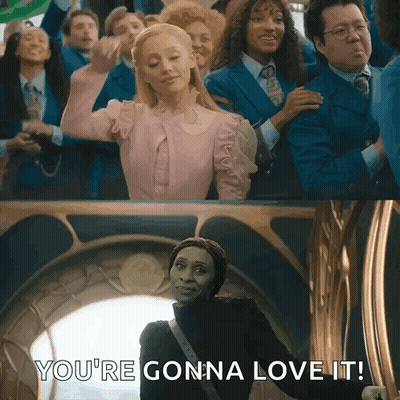 A Woman In A Pink Dress Is Standing In Front Of A Group Of People And Says `` You 'Re Gonna Love It '' . GIF