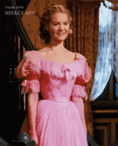 A Woman In A Pink Dress Is Standing In Front Of Stairs Made With Reface App GIF