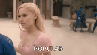 A Woman In A Pink Dress Is Standing Next To A Man And Talking To Him . GIF