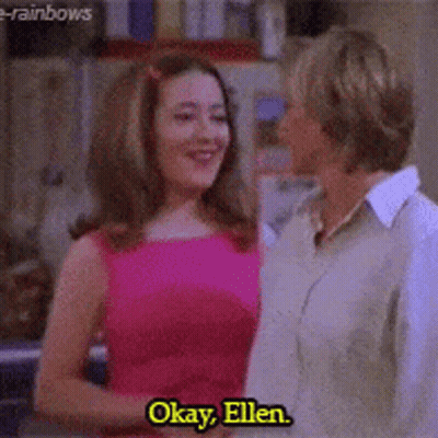 A Woman In A Pink Dress Is Talking To A Woman In A Tan Shirt With The Words Okay Ellen On The Bottom GIF