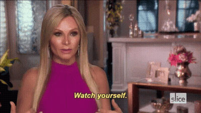 A Woman In A Pink Dress Is Talking To Someone And Says Watch Yourself . GIF