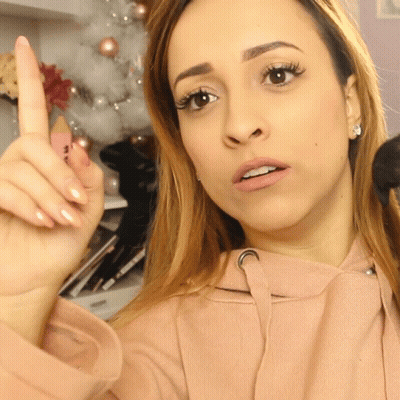 A Woman In A Pink Hoodie Is Giving A Thumbs Up Sign GIF