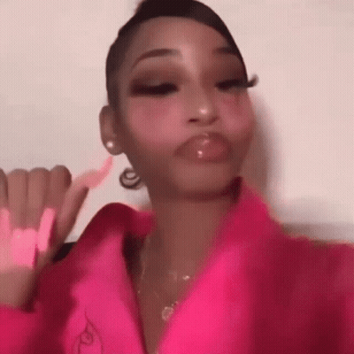 A Woman In A Pink Jacket Is Making A Face . GIF