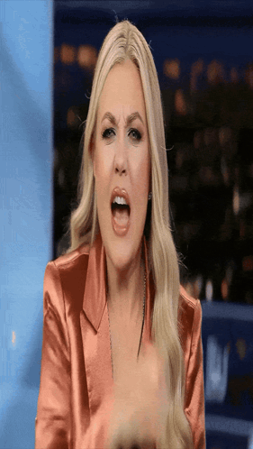 A Woman In A Pink Jacket Is Making A Funny Face With Her Mouth Open GIF