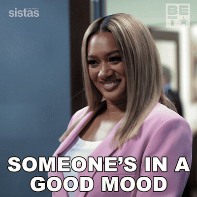 A Woman In A Pink Jacket Is Smiling And Someone 'S In A Good Mood Is Written Below Her GIF
