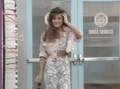 A Woman In A Pink Jacket Is Standing In Front Of A Blue Door That Says Erot2 Theout2 On It GIF