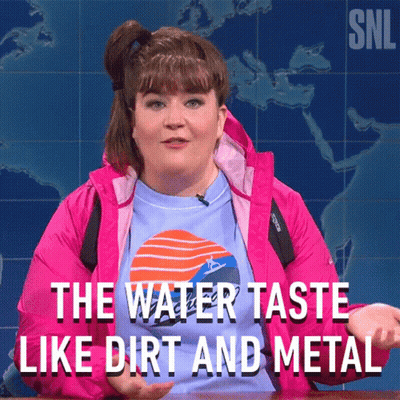A Woman In A Pink Jacket Is Talking About The Water Taste GIF