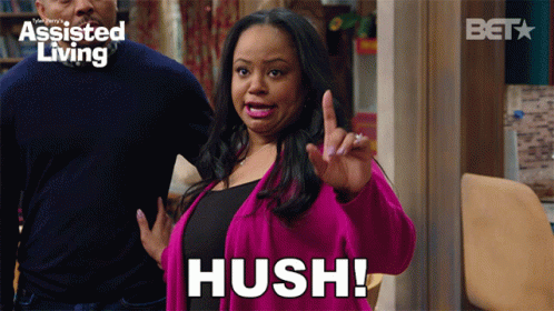 A Woman In A Pink Jacket Says Hush In Front Of A Bet Logo GIF