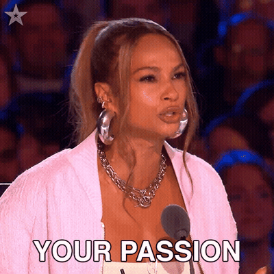 A Woman In A Pink Jacket Stands In Front Of A Microphone And Says " Your Passion " . GIF