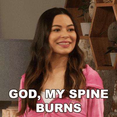 A Woman In A Pink Jacket With The Words God My Spine Burns Below Her GIF
