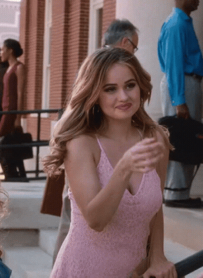A Woman In A Pink Lace Dress Is Standing On A Set Of Stairs GIF