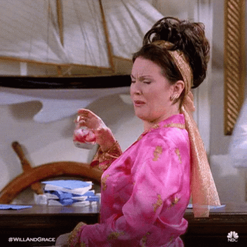 A Woman In A Pink Robe Is Crying While Holding A Glass Of Water . GIF