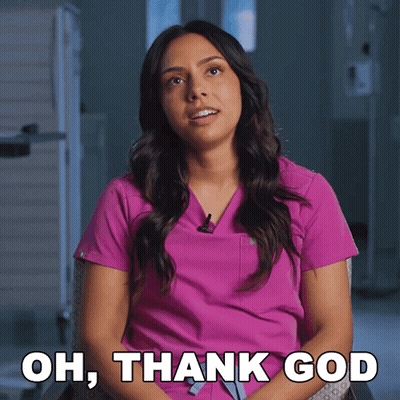 A Woman In A Pink Scrub Is Sitting In A Chair And Says Oh Thank God GIF