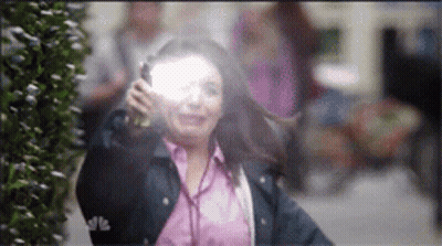 A Woman In A Pink Shirt And A Blue Jacket Is Holding A Flashlight GIF