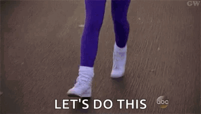 A Woman In A Pink Shirt And Purple Pants Is Running Down A Street And Says `` Let 'S Do This '' . GIF