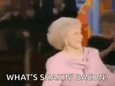 A Woman In A Pink Shirt Is Dancing And Saying What 'S Shakin ' Bacon . GIF