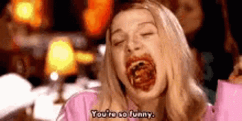 A Woman In A Pink Shirt Is Eating Spaghetti And Saying `` You 'Re So Funny '' . GIF