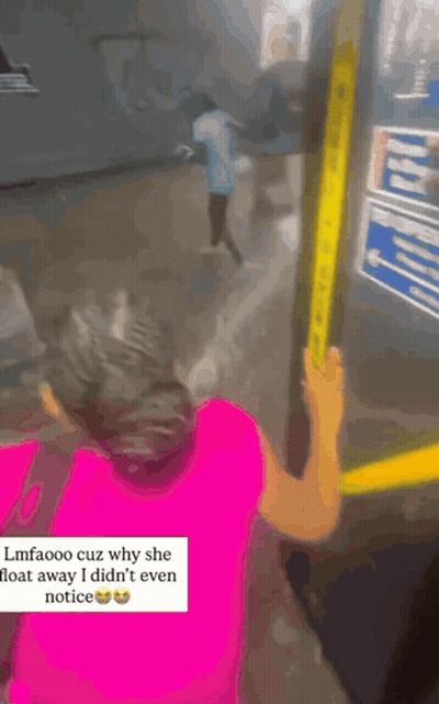 A Woman In A Pink Shirt Is Holding Onto A Yellow Railing While Another Woman Looks On GIF
