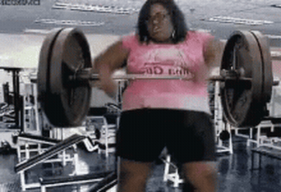 A Woman In A Pink Shirt Is Lifting A Barbell In A Gym GIF