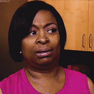 A Woman In A Pink Shirt Is Making A Face GIF