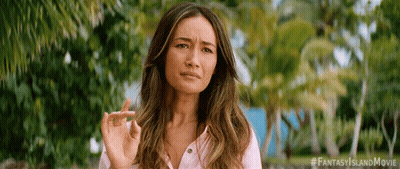 A Woman In A Pink Shirt Is Making A Funny Face While Holding Her Finger Up . GIF