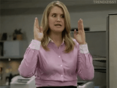 A Woman In A Pink Shirt Is Making A Funny Face With Her Hands Up . GIF