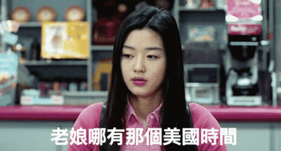 A Woman In A Pink Shirt Is Sitting At A Counter With Chinese Writing On It GIF