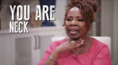 A Woman In A Pink Shirt Is Sitting In A Chair With The Words `` You Are Neck '' Behind Her . GIF