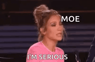 A Woman In A Pink Shirt Is Sitting In Front Of A Microphone And Making A Funny Face . GIF