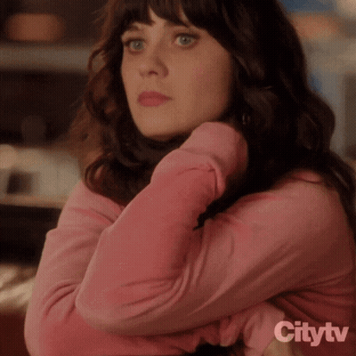 A Woman In A Pink Shirt Is Sitting With Her Arms Crossed In Front Of A Citytv Sign GIF