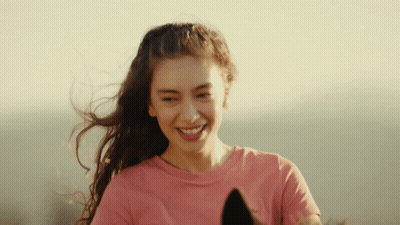 A Woman In A Pink Shirt Is Smiling And Holding A Horse GIF