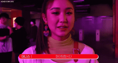 A Woman In A Pink Shirt Is Standing In Front Of A Red Sign That Says ' I 'M Sorry ' . GIF