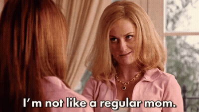 A Woman In A Pink Shirt Is Talking To Another Woman In Front Of A Window . GIF