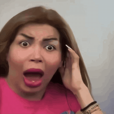 A Woman In A Pink Shirt Making A Surprised Face GIF