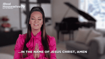 A Woman In A Pink Shirt Prays In Front Of A Piano GIF