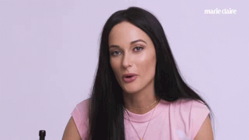 A Woman In A Pink Shirt Says What Happened In White Letters GIF