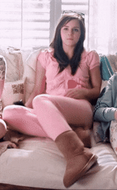 A Woman In A Pink Shirt Sits On A Couch GIF