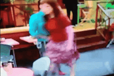 A Woman In A Pink Skirt Is Dancing With A Man In A Blue Shirt In A Blurry Photo . GIF
