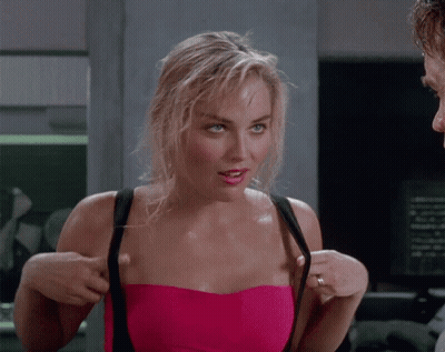 A Woman In A Pink Strapless Top Adjusts Her Straps GIF