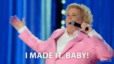 A Woman In A Pink Suit Is Singing Into A Microphone And Says I Made It Baby GIF