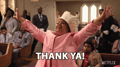 A Woman In A Pink Suit Says Thank Ya In Front Of A Netflix Logo GIF