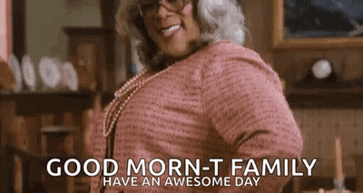A Woman In A Pink Sweater And Glasses Is Smiling And Says `` Good Morning - T Family Have An Awesome Day '' . GIF