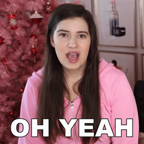 A Woman In A Pink Sweatshirt Says Oh Yeah In Front Of A Pink Christmas Tree GIF