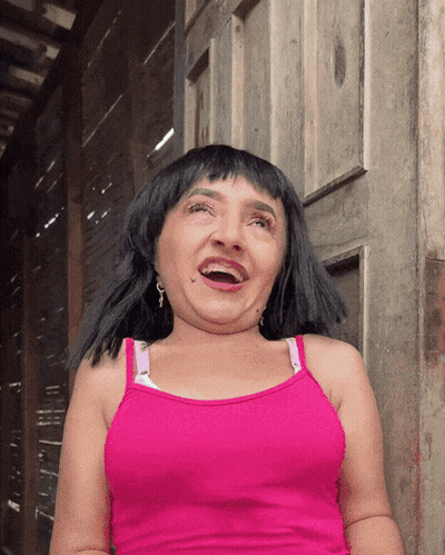 A Woman In A Pink Tank Top Is Making A Face GIF