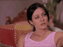 A Woman In A Pink Tank Top Sits On A Couch GIF