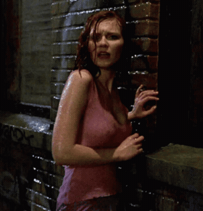 A Woman In A Pink Tank Top Stands In The Rain GIF