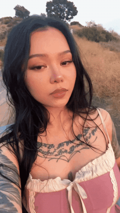 A Woman In A Pink Top Has A Tattoo On Her Chest That Says " I 'M A Girl " GIF